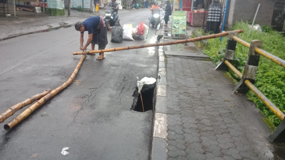 JEBOL : Pemasangan pembatas di sekitar lubang Jalan Raya Darmasaba, Desa Darmasaba, Abiansemal, Minggu (26/2). Ist