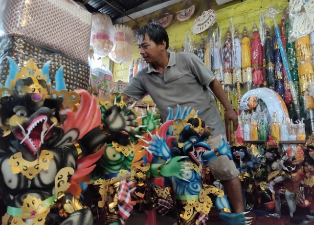 LARIS MANIS : Pedagang sedang merapikan miniatur ogoh-ogoh di tokonya. (DIAN SURYANTINI/BALI EXPRESS)