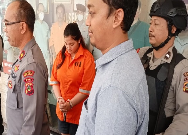 Tertunduk: Ayu hanya bisa tertunduk lesu saat kasusnya melakukan penggelapan dibeberkan di Mapolsek Denpasar Timur. (ISTIMEWA)