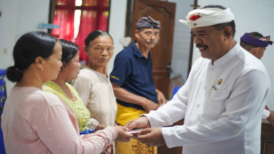 SERAHKAN BANTUAN : Wakil Bupati Klungkung I Made Kasta didampingi Sekretaris Camat Nusa Penida Nyoman Suarta menyerahkan secara simbolis BLT kepada masyarakat Desa Kutampi, Rabu (3/5). Ist