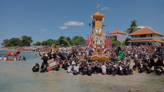DEBURAN OMBAK : Saat pengarakan bade di lakukan di dalam air pesisir pantai bahkan masuk ke deburan ombak. Tradisi ini dilakukan di Desa Adat Kutapang pada Rabu (17/5). Ist