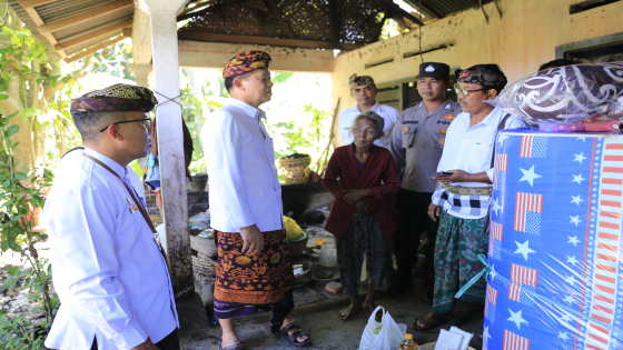 SERAHKAN BANTUAN : Bupati Klungkung Nyoman Suwirta  menyerahkan bantuan kepada Ni Ketut Nanik, 80, lansia sebatangkara barupa rehab rumah, sembako gratis serta bantuan BLTDD, Senin (22/5). Ist