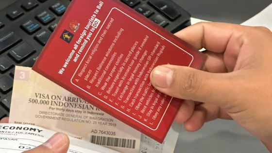SELIPKAN SELEBARAN : Petugas Imigrasi di Bandara Ngurah Rai menyelipkan selebaran pada dokumen keimigrasian wisatawan asing. Ist