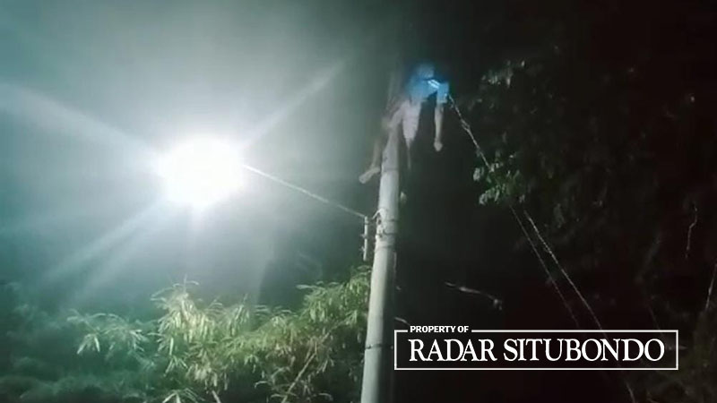 TERSENGAT LISTRIK: Agus Salam warga Dusun Pareyaan Utara, Desa Sumberkolak, Kecamatan Panarukan, Situbondo, tergantung di atas tiang listrik PLN, Minggu malam (30/10).