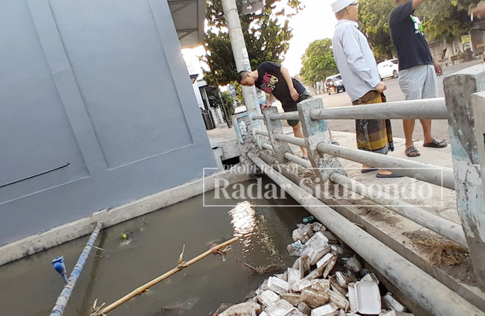 PENUH SAMPAH: Sejumlah warga melihat debit air yang naik di jembatan Jalan Raya Kenanga, Kelurahan Dawuhan, Kecamatan/Kota Situbondo, Minggu (5/10).