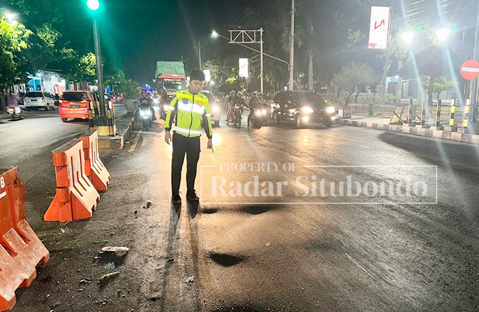 BERGELOMBANG: Anggota Kanitlaka Polres Situbondo menunjukkan lokasi kecelakaan di simpang empat Alun-alun Kota Situbondo, Minggu malam (6/10).