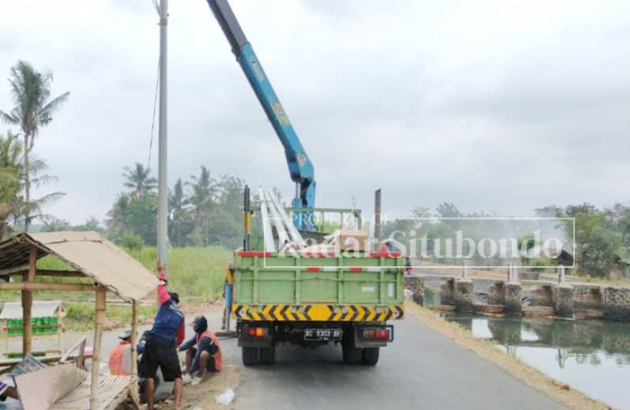 BERTAHAP : Petugas Dishub Situbondo melakukan pemasangan tiang dan lampu&nbsp; PJU, di Desa Jatisari, Kecamatan Arjasa, Selasa (7/11) kemarin.