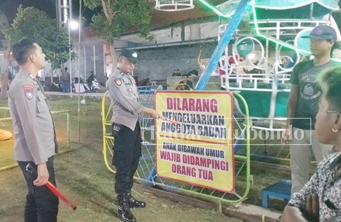OPERASI PASAR MALAM: Anggota Polsek Kapongan memberikan imbauan kepada pengusaha mainan di Taman Lanceng, Desa Kesambirampak, Kecamatan Kapongan, Minggu malam (19/11).