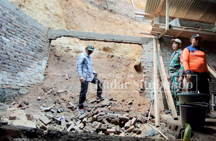 TINJAU LONGSOR: Anggota BPBD Situbondo meninjau dapur milik Jiwar 55, warga Dusun Taman Rejo, Desa Curahtatal, Kecamatan Arjasa, Senin (27/11).