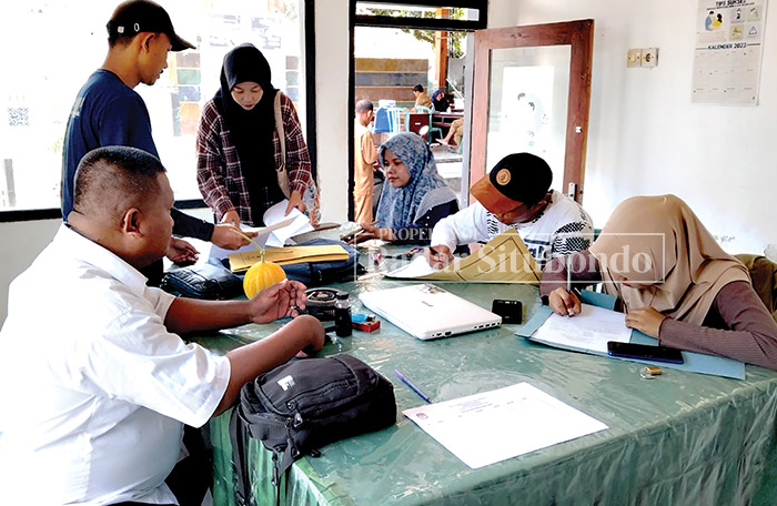 HARI PERTAMA: Warga mengisi formulir pendaftaran calon anggota KPPS, di Desa Sumberkolak, Kecamatan Panarukan, Senin (11/12) kemarin.
