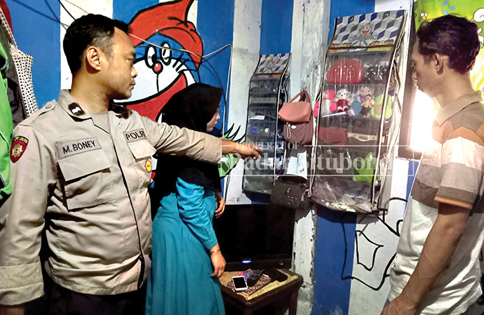 KEHILANGAN UANG: Anggota Polsek melakukan olah TKP di rumah Nur Faidah, 30, warga Kampung Bukkol Manis, Desa Kedungdowo, Kecamatan Arjasa, Senin (11/12).