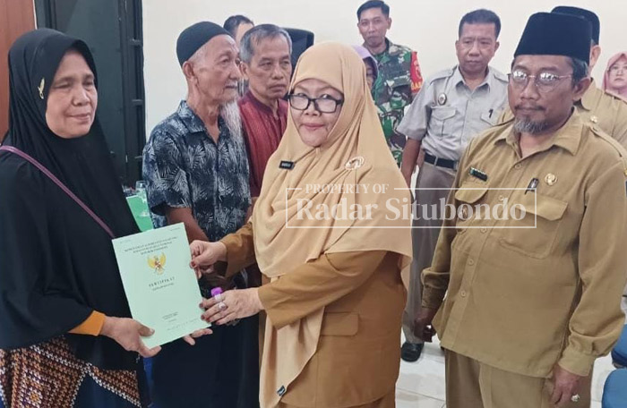 ABADIKAN MOMEN: Wakil Bupati (Wabub) Situbondo Nyai Hj. Khoirani (dua dari kiri) menyerahkan langsung sertifikat PTSL kepada salah satu warga Kelurahan Dawuhan, Kecamatan/Kota Situbondo, kemarin.