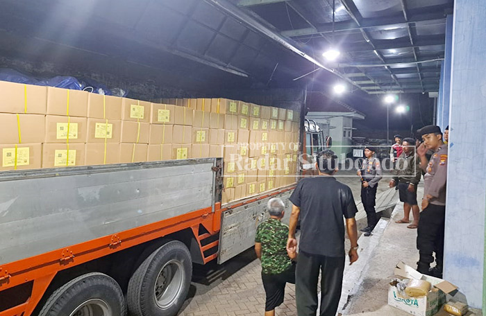 DIGOTONG: Anggota Kepolisian Polres Situbondo melakukan penjagaan saat proses penuruanan surat suara di gudang logistik, di wilatah Kelurahan Mimbaan, Kecamatan Panji.
