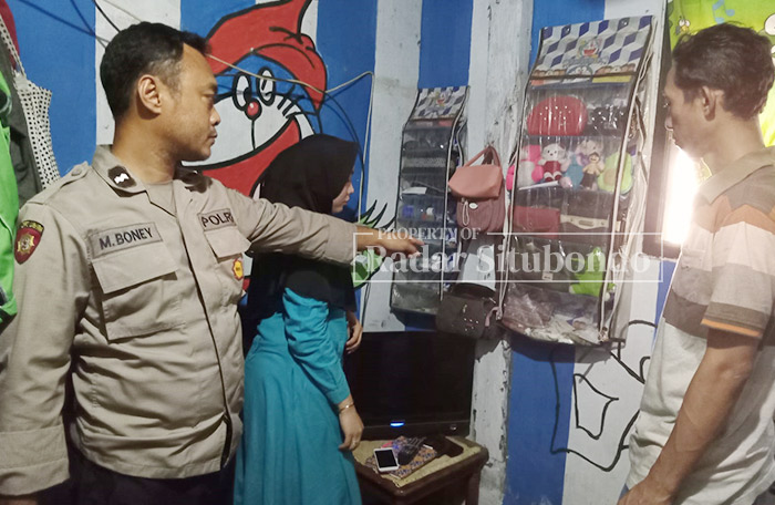 DATANGI RUMAH KORBAN: Kanitreskrim Polsek Arjasa Aipda Singgi (dua dari kiri) melakukan pemeriksaan di rumah Nur Faidah, 30, warga Kampung Bukkol Manis, Desa Kedungdowo, Kecamatan Arjasa.