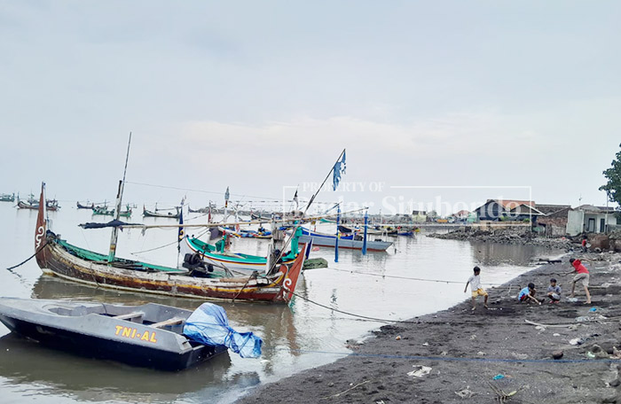 OMBAK TENANG: Sejumlah anak-anak bermain di pinggir Pantai Dusun Pesisir, Desa/kecamatan Panarukan, kemarin (9/2) pukul 13.20.