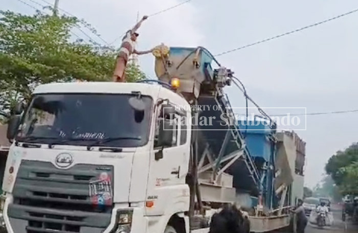 BERBAHAYA: Warga bantu sopir truk mengangkat kabel yang tersangkut pada bodi kendaraan, di Desa/kecamatan Jangkar, Rabu (10/1).