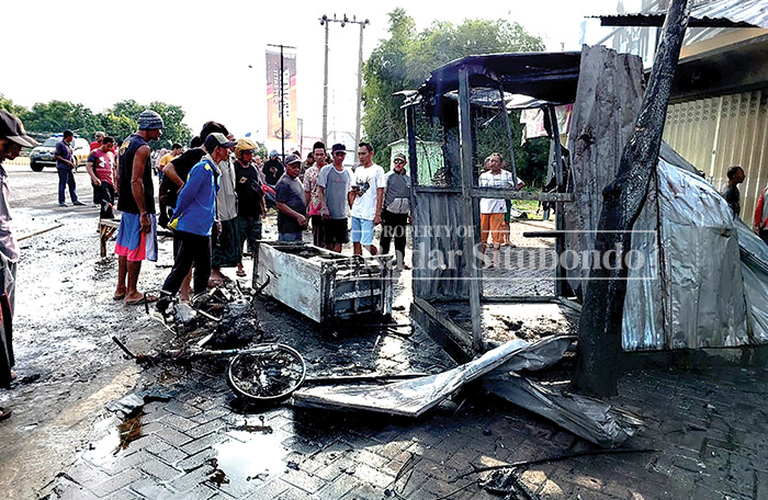 HANGUS: Puluhan warga melihat kondisi pom mini di pinggir Jalan Pantura, milik Johan, 56, warga Dusun Ketu, Desa Demung, Kecamatan Besuki, kemarin (12/2).