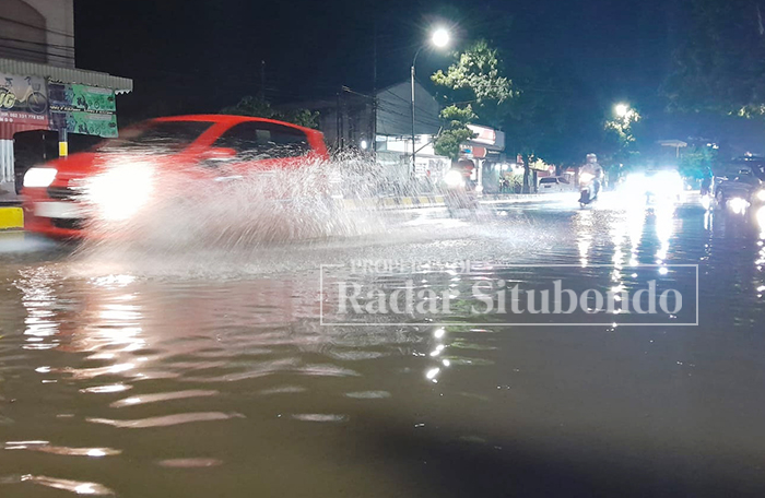 DIKEPUNG AIR: Salah satu warga&nbsp; Kelurahan Dawuhan Lingkungan Parse RT 02, RW 03, Kecamatan/Kota Situbondo, menguras genangan air di halaman rumah, Senin malam (15/1).  &nbsp;