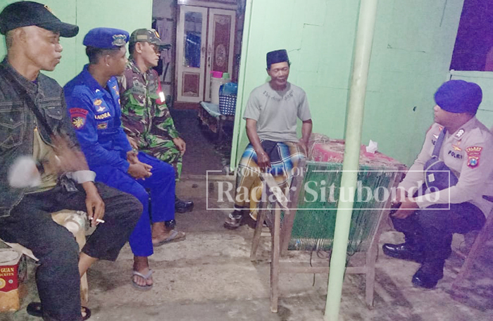 BERBAGI CERITA: Abdur, 65, warga Desa Tanjung Pecinan, Kecamatan Mangaran, (dua dari kanan) menemui anggota Satpolairud Polres Situbondo dan Babinsa setempat di halaman rumah.
