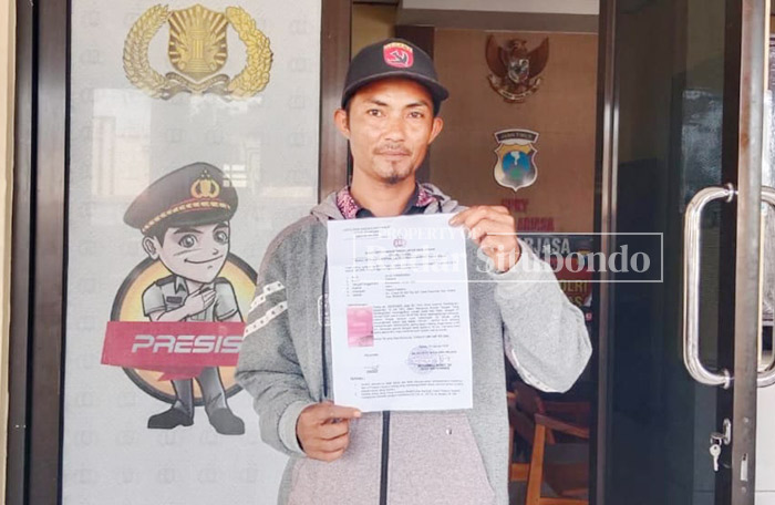 TUNJUKKAN TANDA LAPOR: Cinakip, 45, warga Kampung Cottok, Desa Kayumas, Kecamatan Arjasa, laporan ke kantor Polsek Arjasa, kemarin (21/1).