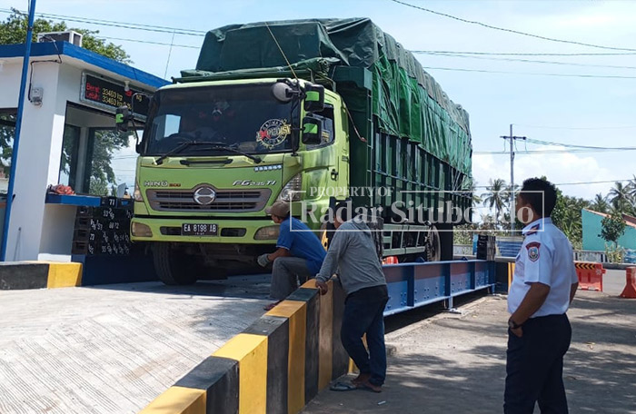 PERSIAPAN : Petugas mengawasi kendaraan truk yang sedang memasuki tempat timbangan, Senin (22/1) lalu.