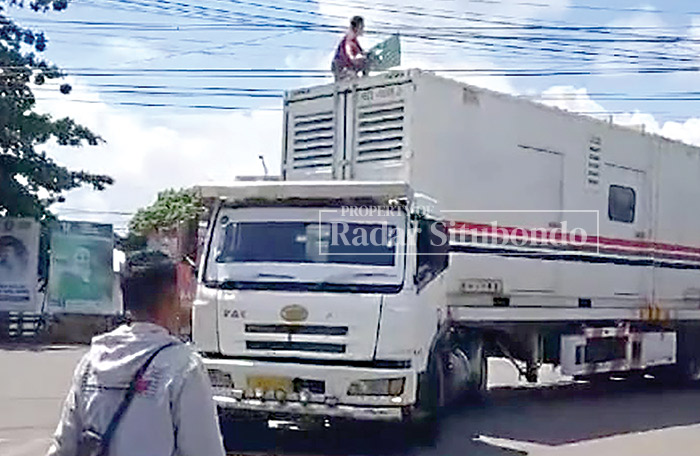 BERBAHAYA: Seorang warga Desa/Kecamatan Jangkar membantu sopir truk yang tersangkut pada jaringan kabel, Minggu (28/1) kemarin.