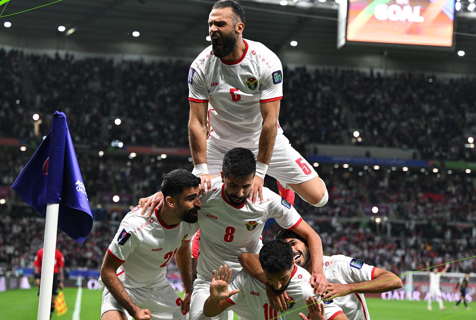 Para pemain Yordania merayakan gol atas Korea Selatan di sudut lapangan.