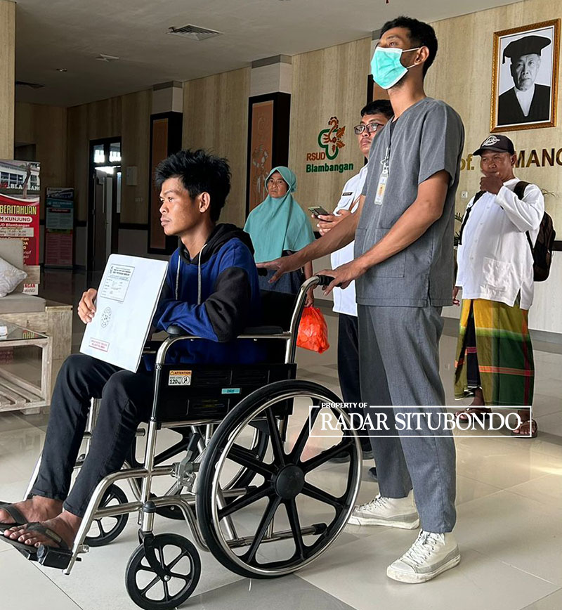 PAKAI KURSI RODA: Budi didampingi ibunya, Paini, memegang hasil pemeriksaan radiologi di RSUD Blambangan Banyuwangi, Rabu (7/2).