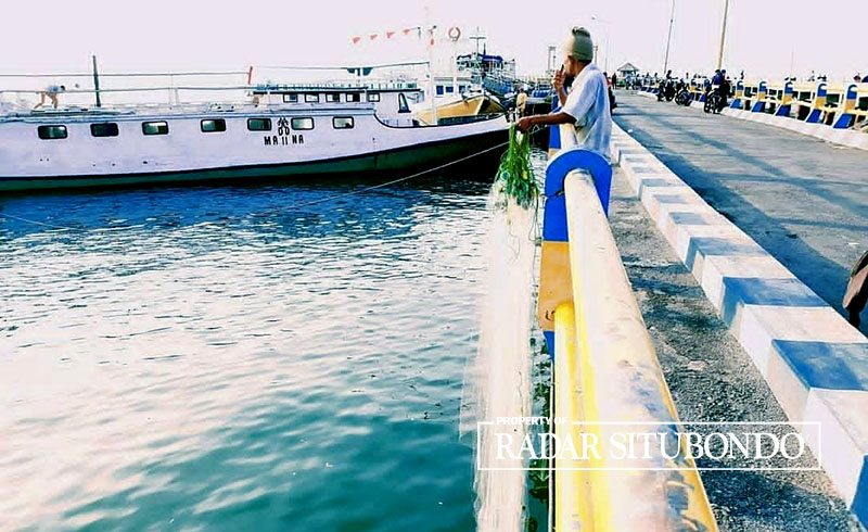 Salah seorang pemancing tengah menunggu sambaran ikan di dermaga lama pelabuhan Jangka, Situbondo.