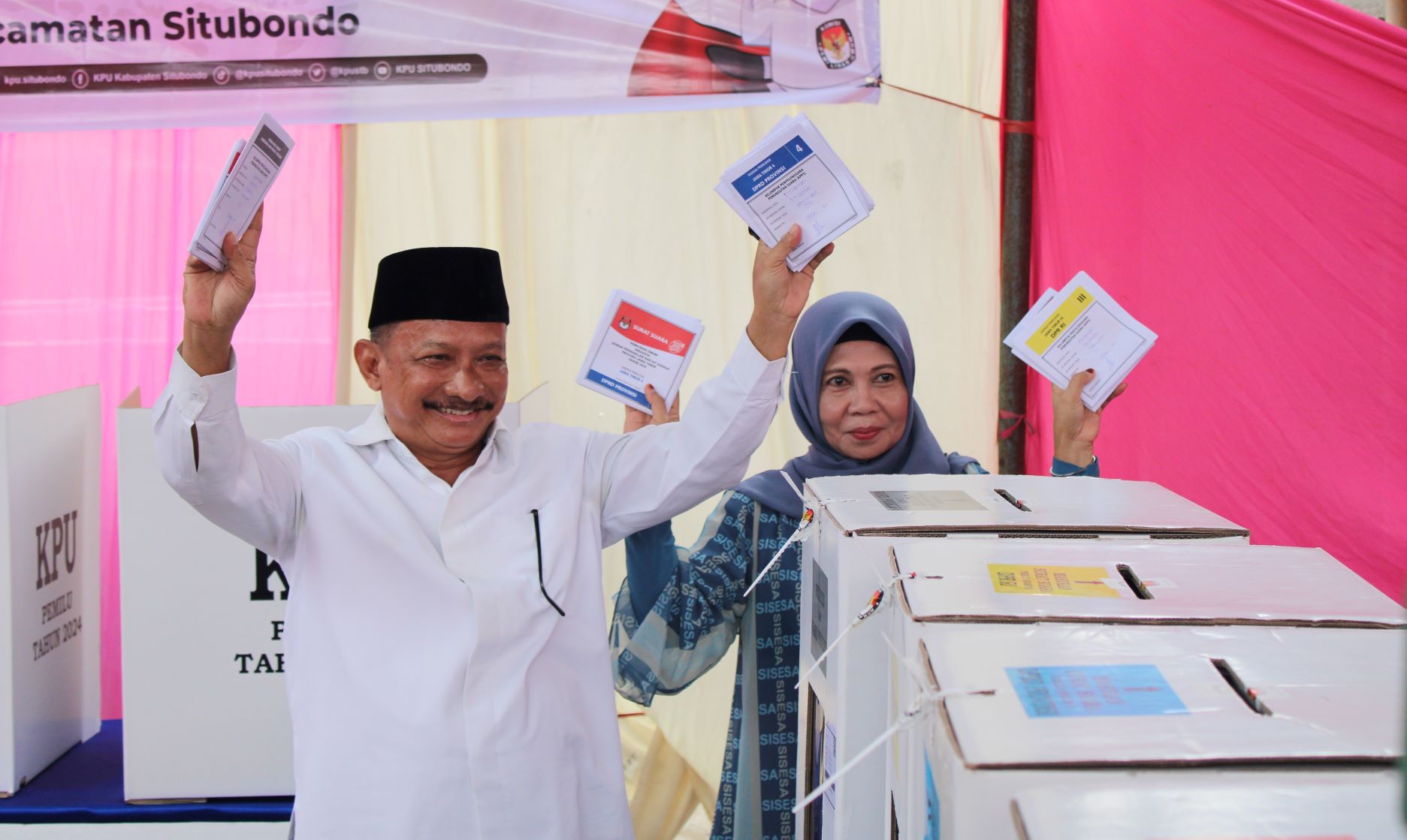 DITUNJUKKAN : Bupati Situbondo, Drs. Karna Suswandi bersama Hj. Juma&rsquo;ati Karna Suswandi menunjukkan surat suara sebelum dimasukkan pada kotak suara di TPS 016, di wilayah Kelurahan Dawuhan.