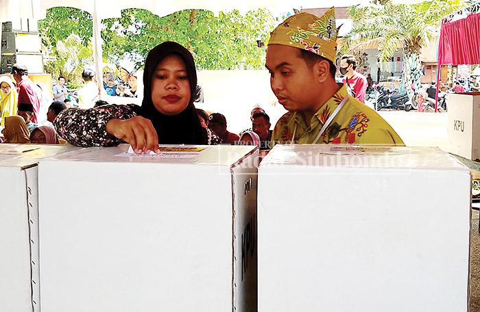 SIMULASI : Seorang warga memasukkan surat suara ke dalam kotak suara didampingi oleh petugas KPPS, di Desa Bletok, Kecamatan Bungatan, beberapa waktu lalu.