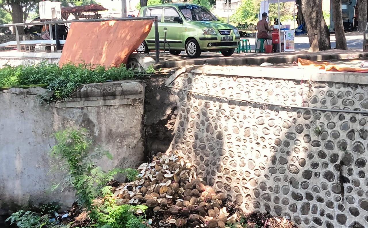 DIKELUHKAN: Kulit durian berserakan di dalam sungai Taman Pancing, Kecamatan Panji, Senin (19/2).