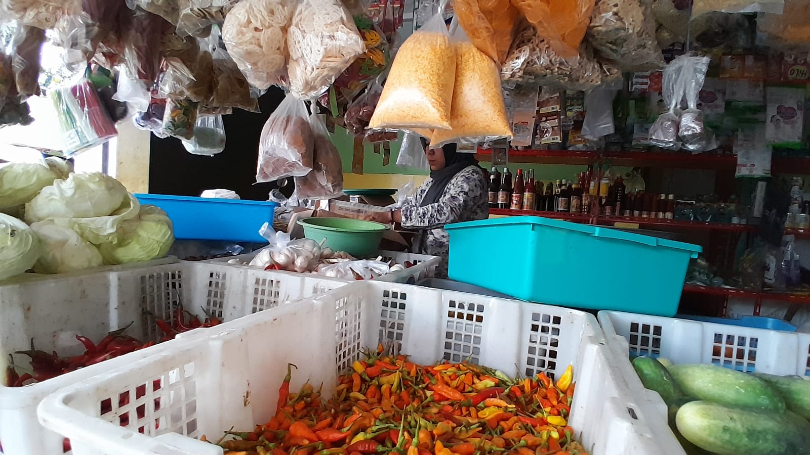 DIKELUHKAN: Penjaga toko kelontong di Pasar Panji bercakap-cakap dengan salah satu pembeli, kemarin (21/2).