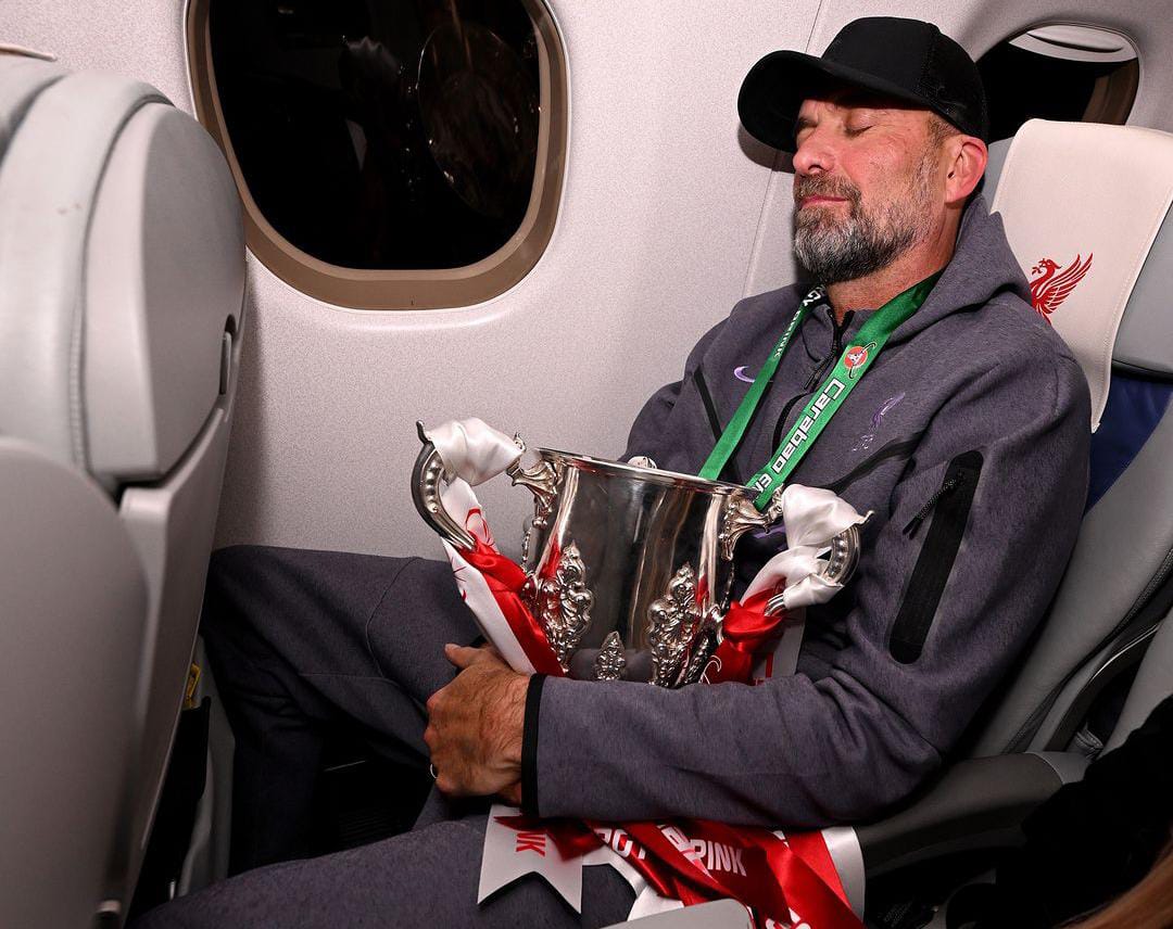 Juergen Klopp memeluk Trofi Carabao Cup di dalam pesawat
