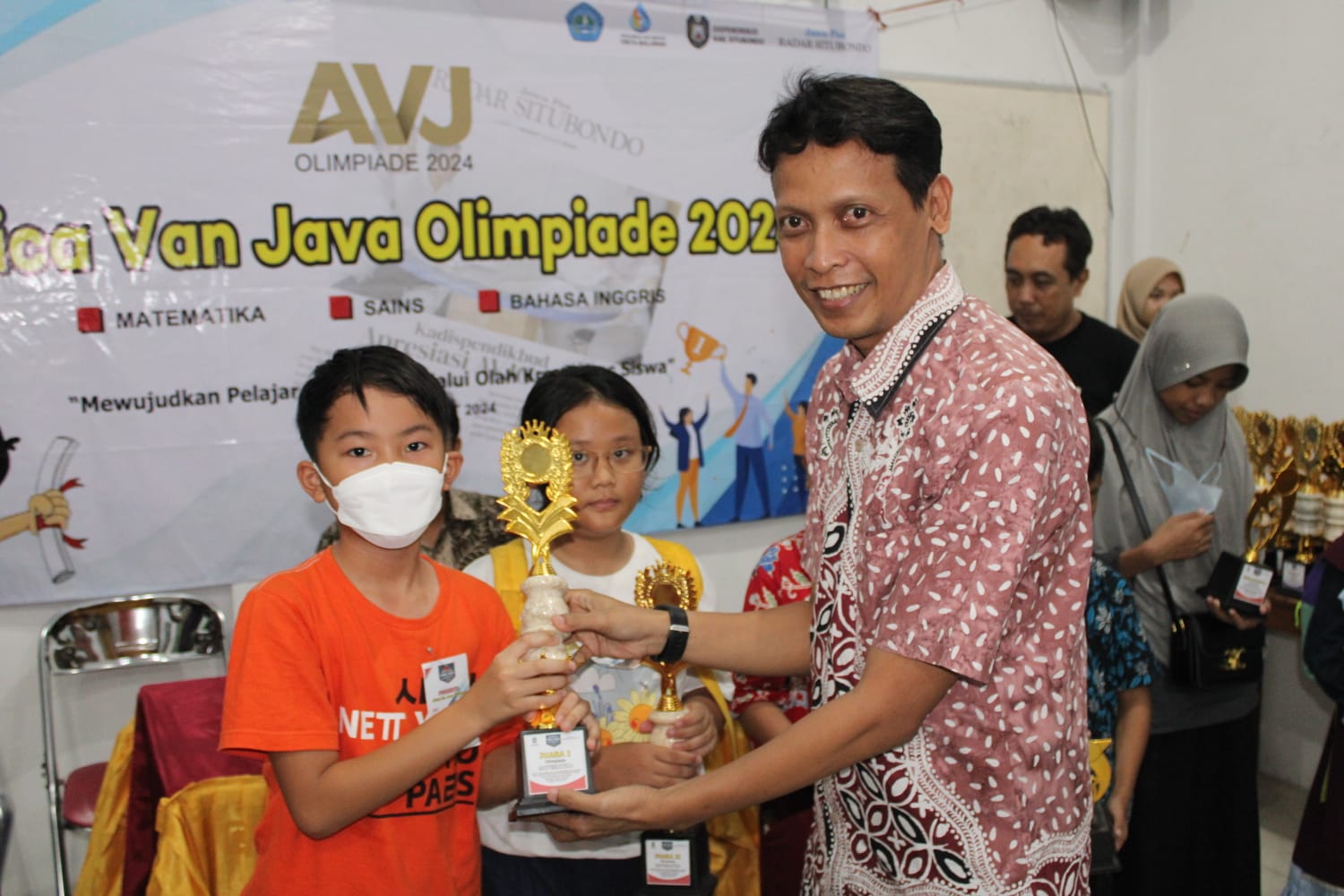 General Manager Jawa Pos Radar Banyuwangi, Rahman Bayu Saksono menyerahkan piala penghargaan kepada salah satu pemenang AVJO