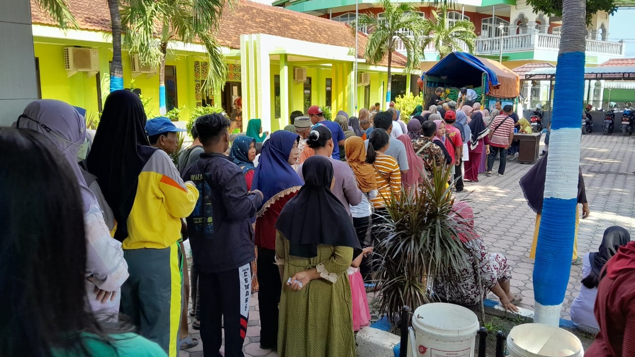 ANTRE: Puluhan warga berbaris di depan kantor Kelurahan Dawuhan, Kecamatan Panji, menunggu giliran mendapatkan pembelian beras murah, kemarin (1/3).