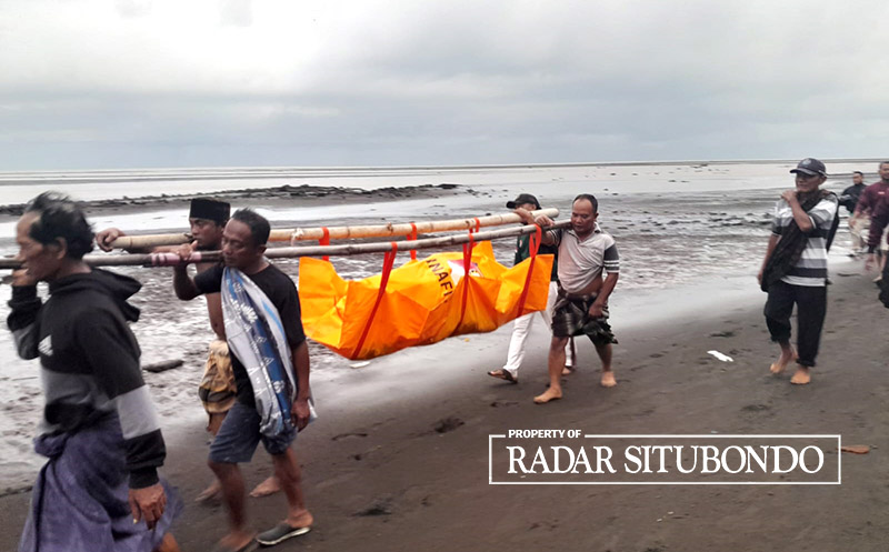 PENEMUAN MAYAT: Sejumlah warga menggotong  jenazah dari Pesisir Pantai, Dusun Ketah Kulon, Desa Demung, Kecamatan Besuki, Situbondo, Selasa (12/3).