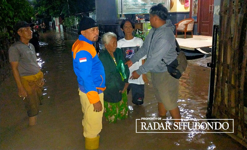 Anggota BPBD Situbondo didampingi warga Desa Kalimas, Kecamatan Besuki, mencari lokasi pembuangan banjir, Minggu malam (17/3) sekitar pukul 22.30 WIB.