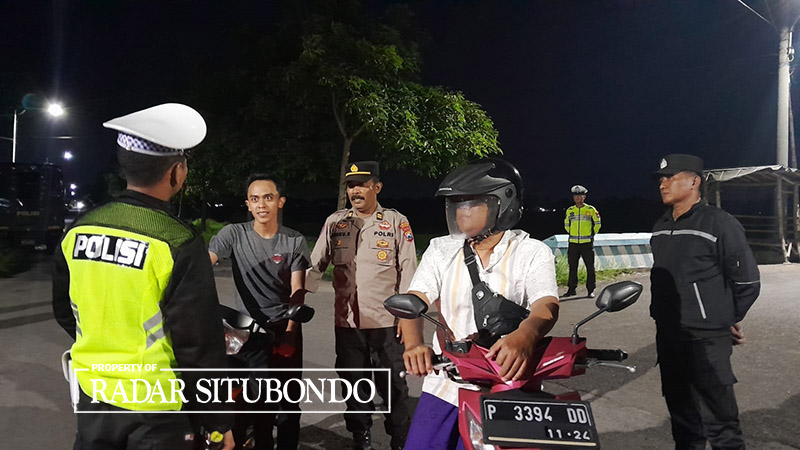 SIAP SIAGA: Dua pengendara diperiksa saat melintas di simpang empat talang, Desa Panji Kidul, Kecamatan Panji, Situbondo, Senin (25/3) pukul 01.00 dini hari.