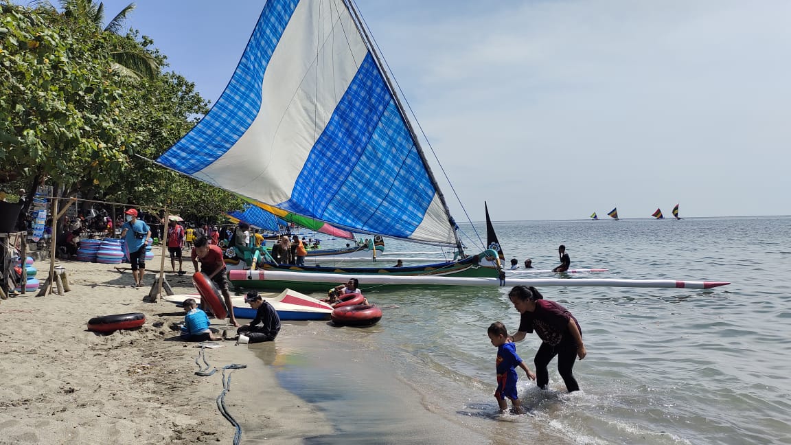 RAMAI: Ribuan wisatawan mandi dan bermain air di wisata Pantai Pasir Putih, Desa Pasir Putih, Kecamatan Bungatan pada Kamis (11/4).