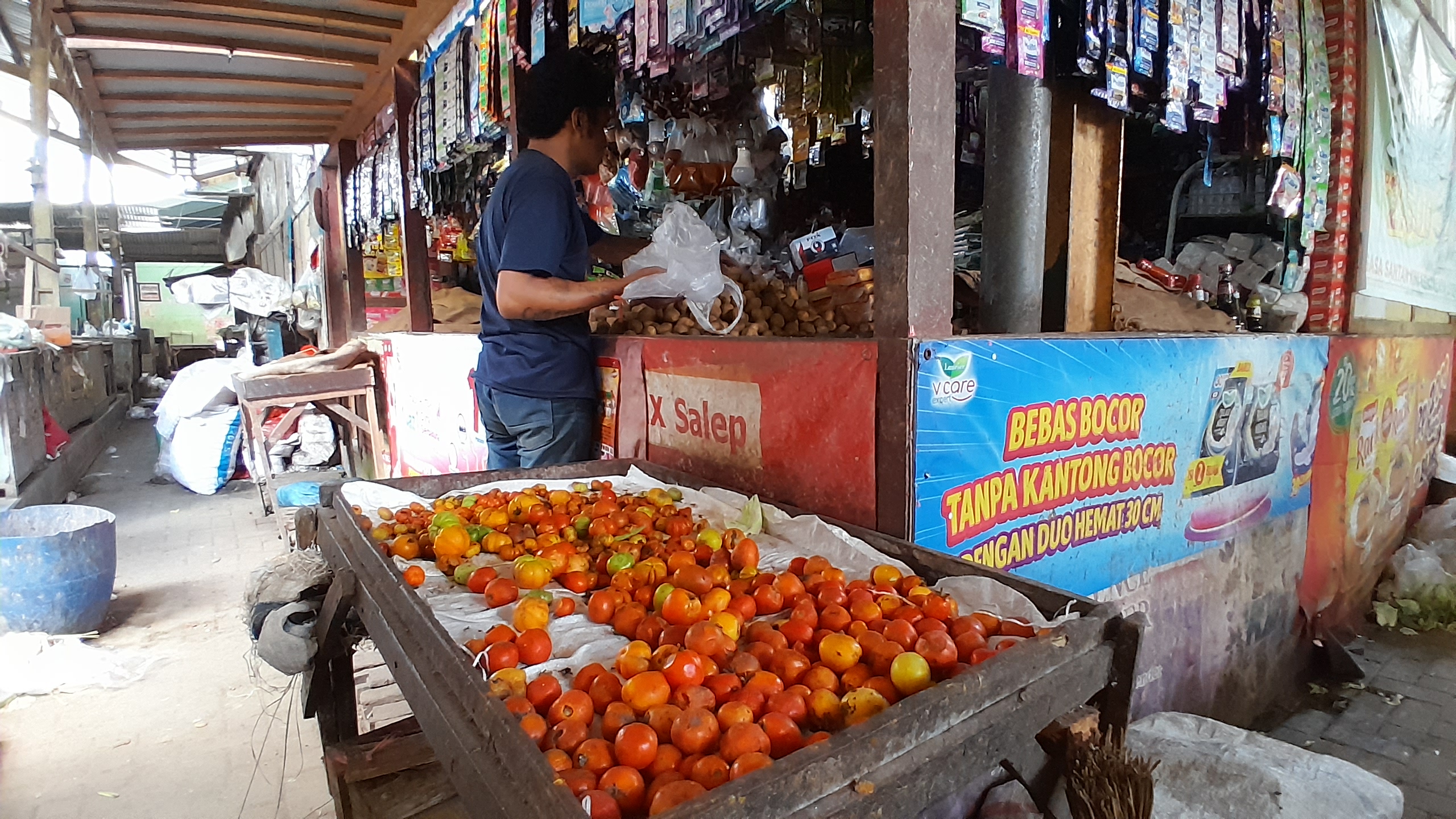 MELEJIT: Tomat dan ranti ditakar di depan toko milik Hosiana di Pasar Panji, Kabupaten Situbondo, Minggu (14/5).