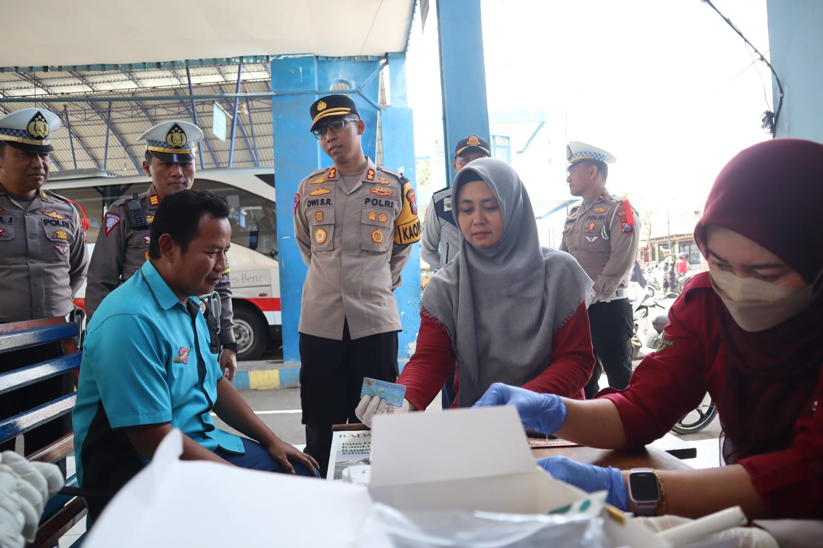 Polisi saat mengecek kesehatan sopir bus di terminal Situbondo. (Khoirul Rizal/RadarSitubondo.id)