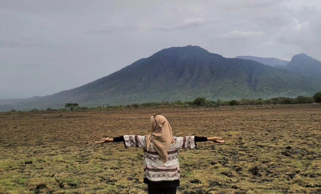 Salah satu pengunjung berfoto di savana bekol Baluran. (ig @myra.dinka_)