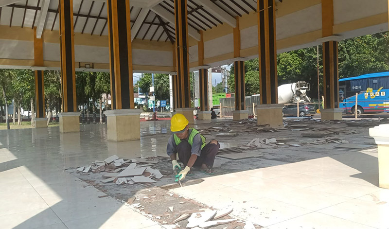 Seorang pekerja membongkar lantai keramik di paseban Alun-Alun Besuki, Desa/Kecamatan Besuki, Situbondo, Senin (20/5).