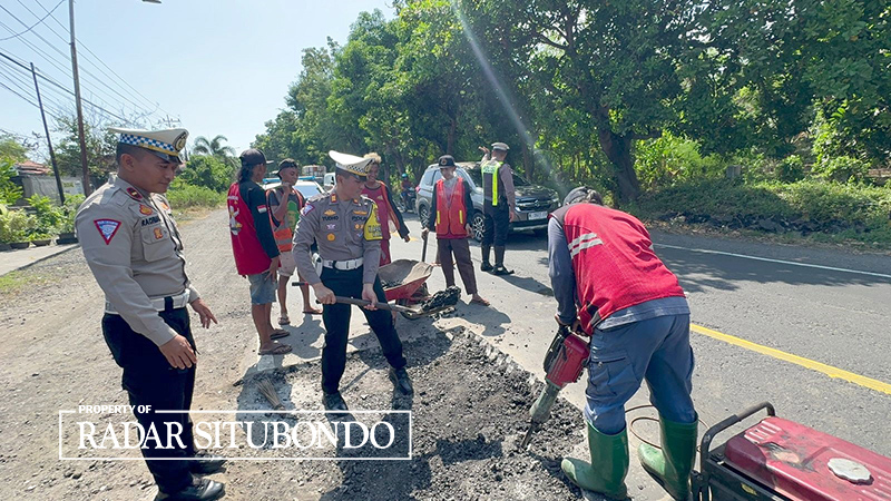 ANTISIPASI LAKA: Anggota Satlantas Polres Situbondo menambal Jalan berlubang di jalur Pantura Kecamatan Mlandingan, Selasa (21/5).