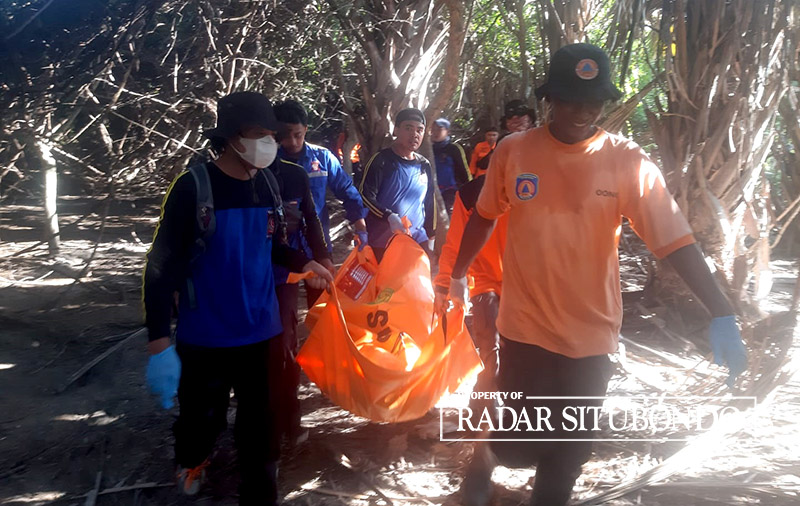 EVAKUASI: Petugas membawa jenazah Misnayu menggunakan kantong mayat, di area hutan Taman Nasional Baluran, Desa Sumberwaru, Kecamatan Banyuputih, Selasa (28/5).