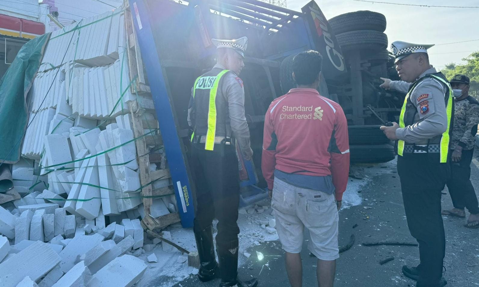 TRUK TERGULING: Anggota Satlantas berkomunikasi dengan sopir Truk Fuso bernopol D 8075 OD di pinggir Jalan Raya, Desa/Kecamatan Asembagus, Situbondo, Senin (3/6).
