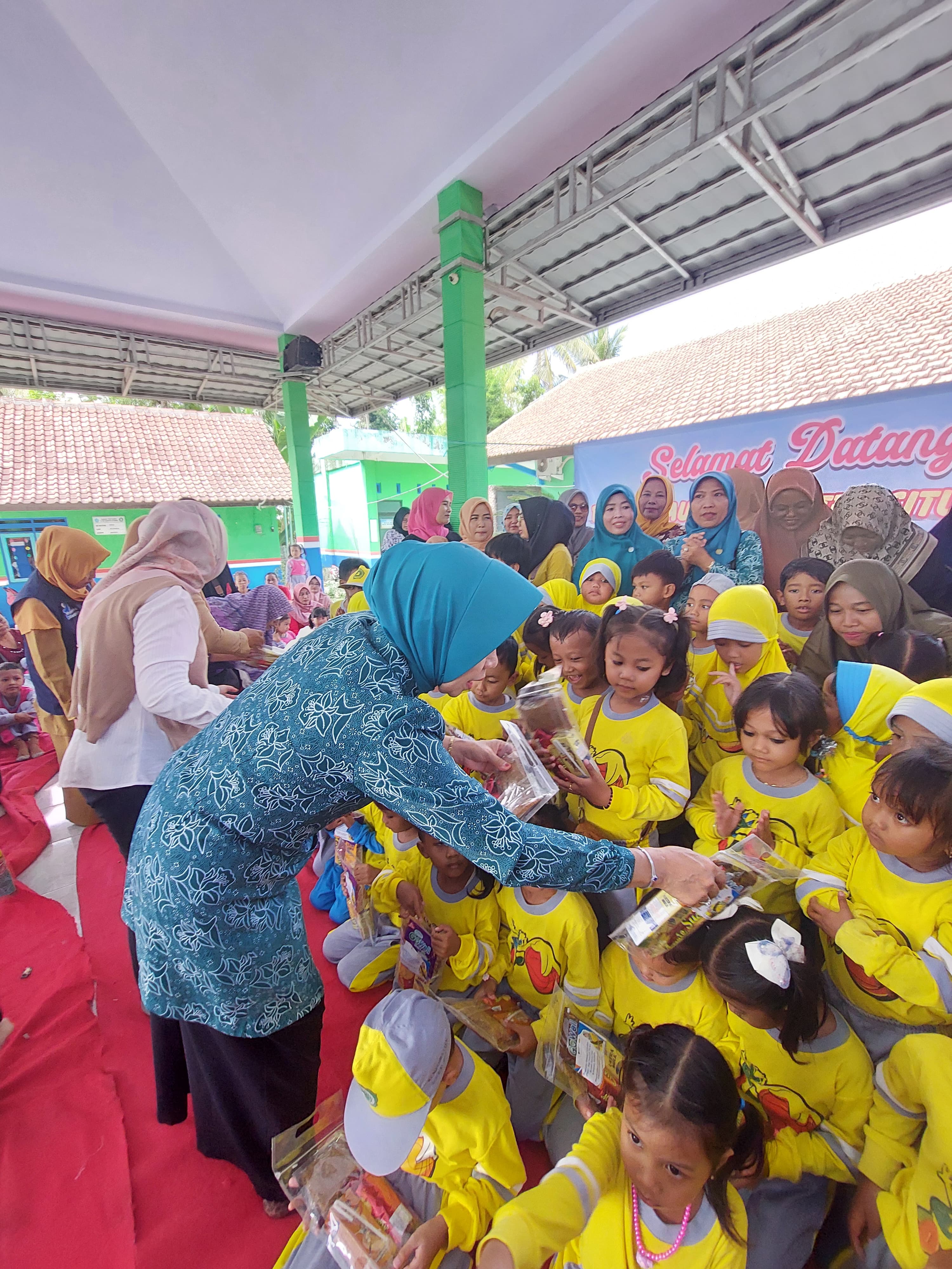 TURUN LANGSUNG: Ketua TP-PKK Kabupaten Situbondo, Hj. Juma&rsquo;ati Karna Suswandi menyerahkan PMT pada anak usia dini di TK Hidayatullah, Desa Wonorejo, Banyuputih.