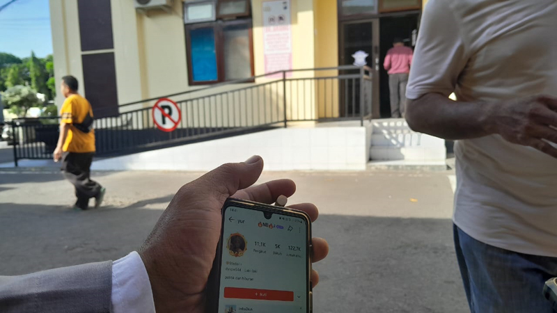 BARANG BUKTI: Salah satu anggota IKSASS menunjukkan akun terlapor ke sejumlah jurnalis di Mapolres Situbondo, Selasa (11/6).