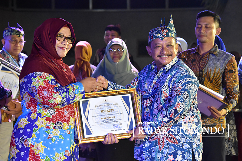 APRESIASI: Bupati Situbondo Drs. Karna Suswandi menyerahkan penghargaan kepada Kepala Dinas Kependudukan dan Catatan Sipil, di pelataran Pendopo Situbondo, Rabu malam (12/6).